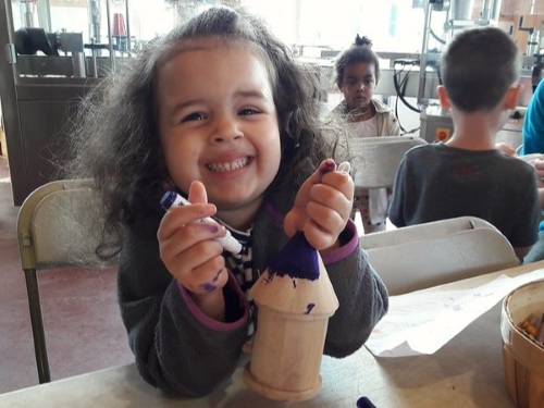 girl painting birdhouse